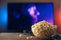 A glass bowl of popcorn, 3d glasses and remote control in the background the TV works. Evening cozy watching a movie or TV series Royalty Free Stock Photo