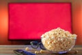 A glass bowl of popcorn, 3d glasses and remote. Royalty Free Stock Photo