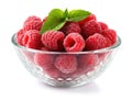 Glass bowl with raspberries and green leaves Royalty Free Stock Photo