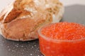Red caviar in a glass bowl and fresh baked bread. Royalty Free Stock Photo
