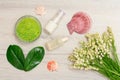 Glass bowl with sea salt, green leaves, bottles with cream for face skin and aromatic oil, sea shells and bouquet of lilies of the Royalty Free Stock Photo