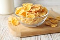 Glass bowl of tasty crispy corn flakes on white wooden table Royalty Free Stock Photo