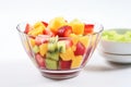 glass bowl with tropical fruit salad on a white surface Royalty Free Stock Photo