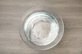 Glass bowl with water on wooden table, top view Royalty Free Stock Photo