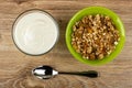 Glass bowl with yogurt, bowl with granola, spoon on table. Top view Royalty Free Stock Photo