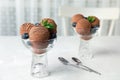 Glass bowls of chocolate ice cream and blueberries served on light table. Royalty Free Stock Photo