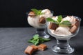 Glass bowls of ice cream with  candies and mint on grey table Royalty Free Stock Photo