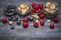 Glass bowls with ingredients for healthy breakfast - muesli,berries and nuts on blue rustic wooden background