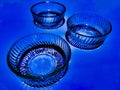 Glass bowls isolated in blue background. Royalty Free Stock Photo