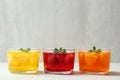 Glass bowls of natural jelly desserts on light table, space