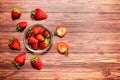 A glass bowls with strawberries on a wooden table. Royalty Free Stock Photo