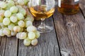 Glass of brandy with brush of grapes on table, harvest holiday Royalty Free Stock Photo