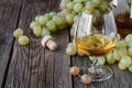 Glass of brandy with brush of grapes on table, harvest holiday Royalty Free Stock Photo