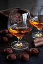 Glass of brandy  or cognac and  chocolate truffles on dark table Royalty Free Stock Photo