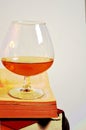 A glass brandy cognac wisky drink on old books