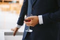 A glass of brandy in the hands of the groom