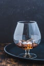 Glass of brandy with ice cubes/Glass of brandy with ice cubes on a black tray Royalty Free Stock Photo