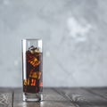 Glass of brew cold coffee and ice. Cold summer drink on a dark wooden table and gray background with copy space Royalty Free Stock Photo