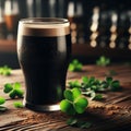 Glass of dark stout sits on wooden table, with sprinkling of shamrocks