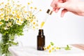 Glass brown bottle of essence or serum and with chamomile flowers Royalty Free Stock Photo