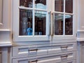 Glass built-in display cabinet in a kitchen, displaying fine china dishes and crystal pitchers