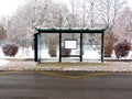 Glass bus shelter in urban setting. snowy sidewalk. modern design Royalty Free Stock Photo