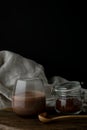 Glass with cacao and a glass jug with cocoa powder