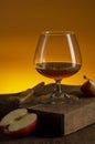 Glass of Calvados Brandy and red apples on wooden table Royalty Free Stock Photo