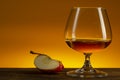 Glass of Calvados Brandy and red apples on wooden table Royalty Free Stock Photo