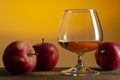 Glass of Calvados Brandy and red apples on wooden table Royalty Free Stock Photo