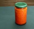 A glass can full of homemade ajvar. A baked bell peppers. South-European specialty. Mediterranean Kitchen.