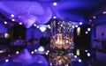 Glass candle light on background of the purple events room. Crystal glass lights indoor of party hall. Beautiful violet decoration