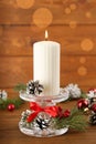 Glass candlestick with burning candle and Christmas decor on wooden table Royalty Free Stock Photo