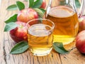 Glass and carafe of fresh apple juice and organic apples on dark old wooden table Royalty Free Stock Photo