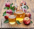 Glass and carafe of fresh apple juice and organic apples on dark old wooden table Royalty Free Stock Photo