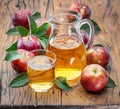 Glass and carafe of fresh apple juice and organic apples on dark old wooden table Royalty Free Stock Photo