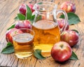 Glass and carafe of fresh apple juice and organic apples on dark old wooden table Royalty Free Stock Photo