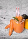 A glass of carrot beverage on a wooden background. A cocktail with carrots and zucchinis. Vegetarian juices. Copy space. Royalty Free Stock Photo