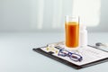 Glass of carrot juice, eyeglasses, vitamins for good vision and Snellen table Royalty Free Stock Photo