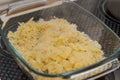 Glass casserole dish with cheese Spaetzle, a south german specialty food made of lumps of dough standing on oven