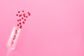 Glass of champagne with red hearts on a pink background. Valentines background, love, date concept with copy space, flatlay