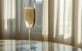 A glass of champagne on a table with a window behind it Royalty Free Stock Photo