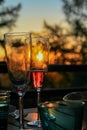 Glass of champagne or wine on table on terrace during evening. Sunset and trees in the background. Home comfort, relaxation, calm Royalty Free Stock Photo