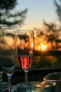 Glass of champagne or wine on table on terrace during evening. Sunset and trees in the background. Home comfort, relaxation, calm Royalty Free Stock Photo