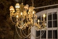 Glass chandelier. Ceiling light source. Lamps shine through a vintage chandelier. Royalty Free Stock Photo