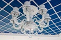 Glass chandelier on the ceiling. Stylish blue ceiling, divided into squares. Royalty Free Stock Photo