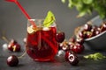 Glass of cherry lemonade with fresh juicy cherries and mint, berries, juice