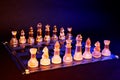 Glass chess on a chessboard lit by blue and orange light