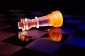 Glass chess on a chessboard lit by blue and orange light