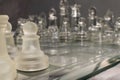 Glass chess pieces arranged on a glass chess board Royalty Free Stock Photo